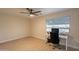 Bright bedroom featuring a ceiling fan, a window with natural light, and a desk set up for work at 10018 N 103Rd Ave, Sun City, AZ 85351