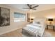 Well-lit bedroom with a ceiling fan, large window, and stylish furnishings at 10018 N 103Rd Ave, Sun City, AZ 85351