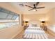 This cozy bedroom has a ceiling fan, a large window, and decorative lamps at 10018 N 103Rd Ave, Sun City, AZ 85351