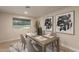 Cozy dining room features a rustic wooden table set for four, complemented by modern artwork at 10018 N 103Rd Ave, Sun City, AZ 85351