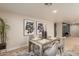 Bright dining area with a rustic wooden table, surrounded by elegant decor and artwork at 10018 N 103Rd Ave, Sun City, AZ 85351