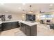 Modern kitchen island with white countertop and dark cabinets offers style and functionality in an open living space at 10018 N 103Rd Ave, Sun City, AZ 85351