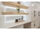 Bright kitchen area showcasing floating wooden shelves, stylish cabinetry, and sleek countertops at 10018 N 103Rd Ave, Sun City, AZ 85351