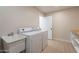 Well-lit laundry room featuring a sink, washer, dryer, and storage cabinets, offering functionality and convenience at 10018 N 103Rd Ave, Sun City, AZ 85351