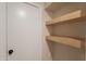 Functional storage area featuring light wood shelving and a white door with a black door knob at 10018 N 103Rd Ave, Sun City, AZ 85351