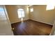 A well-lit bedroom with laminate floors featuring a large window that provide natural light at 10039 W Kingman St, Tolleson, AZ 85353