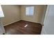 Bedroom featuring sleek hardwood flooring, cream walls, and a window at 10039 W Kingman St, Tolleson, AZ 85353