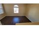 Well-lit living room featuring sleek hardwood flooring and a half-moon window at 10039 W Kingman St, Tolleson, AZ 85353