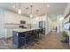 Modern kitchen featuring a large island with seating, sleek appliances, and stylish pendant lighting at 1232 E Silver Reef Dr, Casa Grande, AZ 85122