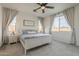 Bright main bedroom featuring soft carpet, ceiling fan, and bright windows at 1232 E Silver Reef Dr, Casa Grande, AZ 85122