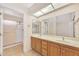 Bathroom with a double sink vanity, large mirror and walk-in shower with glass doors at 13764 W Meeker Blvd, Sun City West, AZ 85375