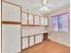 Bedroom with wood floors, window with blinds, ceiling fan, and white storage cabinets at 13764 W Meeker Blvd, Sun City West, AZ 85375