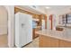 Bright kitchen with an island, wooden cabinetry, and modern white appliances including refrigerator, oven, and cooktop at 13764 W Meeker Blvd, Sun City West, AZ 85375