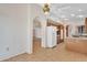 Spacious kitchen with wooden cabinetry, tiled floor, white appliances and arched doorways to other rooms at 13764 W Meeker Blvd, Sun City West, AZ 85375