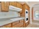 Close-up shot of a kitchen with wood cabinetry, white cooktop, tile backsplash and modern appliances at 13764 W Meeker Blvd, Sun City West, AZ 85375