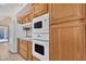 Close-up of a kitchen featuring wooden cabinetry, modern appliances, and a white cooktop at 13764 W Meeker Blvd, Sun City West, AZ 85375