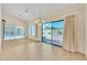 Bright living room featuring tiled floors, fan, chandelier, and sliding glass door with view of the yard at 13764 W Meeker Blvd, Sun City West, AZ 85375