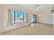 Bright living room featuring tiled floors, chandelier, a large window, and a sliding glass door at 13764 W Meeker Blvd, Sun City West, AZ 85375