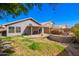 Landscaped backyard with a covered patio, lush greenery, a block wall, and mature shade trees at 1421 E Gary Dr, Chandler, AZ 85225