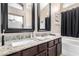 Bathroom with dual sinks, granite countertops, wood cabinets, and framed mirrors at 1421 E Gary Dr, Chandler, AZ 85225