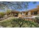 Spacious outdoor kitchen and BBQ area for entertaining, complemented by a lush green lawn at 15135 E Monument Rd, Scottsdale, AZ 85262