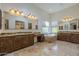 Large primary bathroom with dual vanities, soaking tub, and travertine tile at 15135 E Monument Rd, Scottsdale, AZ 85262