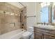 Stylish bathroom featuring a shower-tub, a decorative tile wall and vanity with marble countertops at 15135 E Monument Rd, Scottsdale, AZ 85262