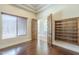 Bright bedroom featuring dark wood floors, built-in shelving, and natural light from a window at 15135 E Monument Rd, Scottsdale, AZ 85262