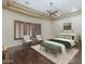 Bright bedroom with wood floors, tray ceiling with fan, and plantation shutters at 15135 E Monument Rd, Scottsdale, AZ 85262