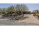 Desert home with stone accents, three-car garage, and desert landscaping in front yard at 15135 E Monument Rd, Scottsdale, AZ 85262