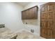 Functional laundry room featuring granite countertops and ample cabinet space at 15135 E Monument Rd, Scottsdale, AZ 85262