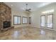 Bright living room with a stone fireplace, tile flooring, and French doors to the outside at 15135 E Monument Rd, Scottsdale, AZ 85262