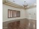 Spacious room featuring wood floors, a tray ceiling with fan, and plantation shuttered windows at 15135 E Monument Rd, Scottsdale, AZ 85262