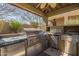 Outdoor kitchen featuring stainless steel grill, sink, refrigeration, and countertop space at 15135 E Monument Rd, Scottsdale, AZ 85262