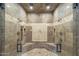 Walk in shower featuring dual shower heads, travertine tile, and built in bench seating at 15135 E Monument Rd, Scottsdale, AZ 85262