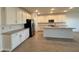Modern kitchen with white cabinetry, quartz countertops, and stainless steel appliances at 15781 W Cheryl Dr, Waddell, AZ 85355