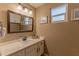 Well-maintained bathroom featuring a vanity with sink and modern fixtures beneath the mirrored cabinet at 1749 E Medlock Dr, Phoenix, AZ 85016