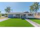 Charming single-story home featuring a manicured lawn, blue shutters and inviting front porch at 1749 E Medlock Dr, Phoenix, AZ 85016