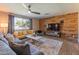 Bright living room featuring wood paneling, ceiling fan, a large window and comfortable couches at 1749 E Medlock Dr, Phoenix, AZ 85016