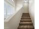 Carpeted staircase with white walls, window and trim leading to the upper level of the home at 18250 N Cave Creek Rd # 105, Phoenix, AZ 85032