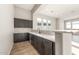 Modern wet bar featuring dark wood cabinetry, quartz countertops, and tile backsplash at 18742 N 269Th Ln, Buckeye, AZ 85396