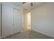 Bedroom with sliding closet doors, adjacent entry door, neutral carpet, and a ceiling fan at 22644 E Quintero Ct, Queen Creek, AZ 85142