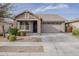 Charming single-story home with stone accents, a well-manicured lawn, and a two-car garage at 22644 E Quintero Ct, Queen Creek, AZ 85142