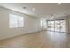 Spacious living room with light wood floors, a ceiling fan, and sliding glass doors to the patio at 22644 E Quintero Ct, Queen Creek, AZ 85142