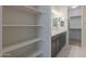 Walk-in closet featuring white shelving, leading to a bright bathroom with grey vanity at 22644 E Quintero Ct, Queen Creek, AZ 85142