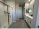 Modern bathroom featuring double sinks, white cabinetry, and a walk-in glass shower at 22808 E Roundup Way, Queen Creek, AZ 85142