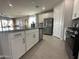 A well-lit kitchen features stainless steel appliances, white cabinetry, and an island with a sink for efficient meal preparation at 22808 E Roundup Way, Queen Creek, AZ 85142