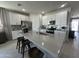 Bright kitchen featuring white cabinets, stainless steel appliances, a large island, and stylish bar stool seating at 22808 E Roundup Way, Queen Creek, AZ 85142