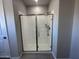 Enclosed glass shower with gray tile flooring, a showerhead, and a sliding glass door at 22808 E Roundup Way, Queen Creek, AZ 85142