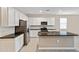 Open kitchen with white cabinets, stainless steel appliances, and a dark countertop island at 24220 W Ripple Rd, Buckeye, AZ 85326